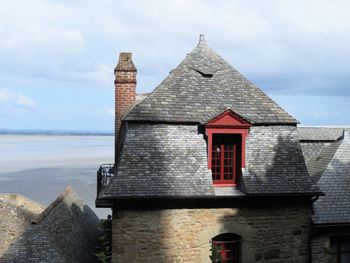 Exterior of building by sea against sky