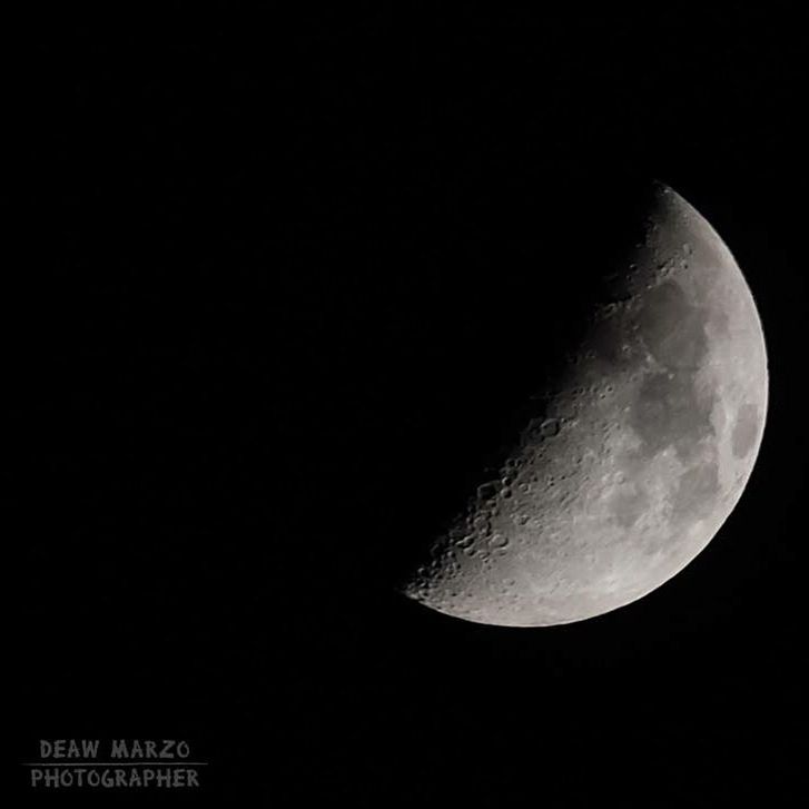 LOW ANGLE VIEW OF MOON OVER BLACK BACKGROUND