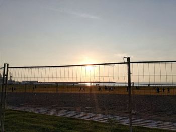 Fence against sky during sunset