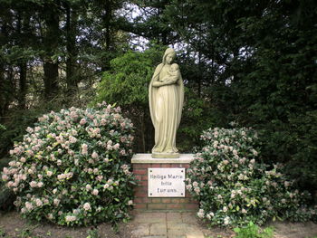 Statue amidst plants against trees