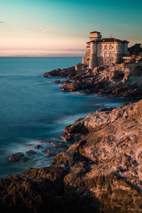 Scenic view of sea by buildings against sky