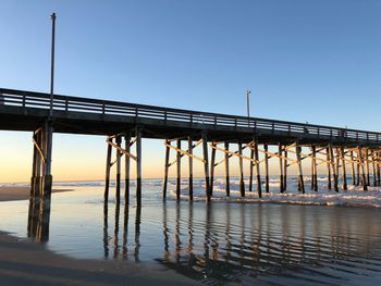 Bridge over sea against clear sky