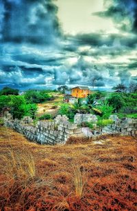 House on field against cloudy sky