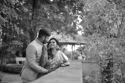 Couple kissing against plants