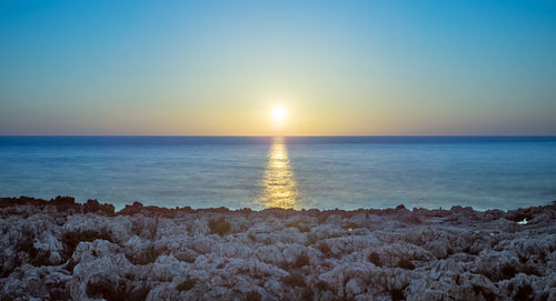 Scenic view of sea against clear sky during sunset