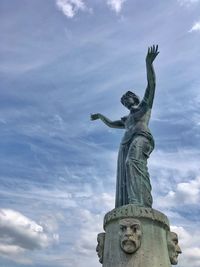 Low angle view of angel statue against cloudy sky