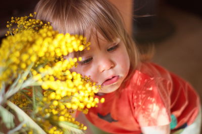 Close-up portrait of cute girl with red flower