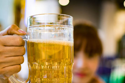 Close-up of hand holding beer glass