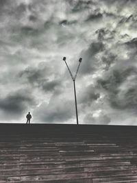 Low angle view of people against cloudy sky