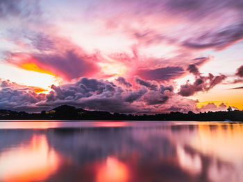 Scenic view of dramatic sky over lake during sunset