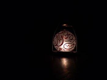 Close-up of illuminated lamp against black background