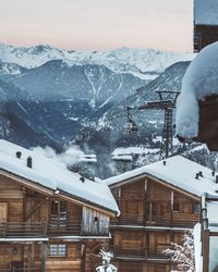 Snow covered houses and mountains against sky