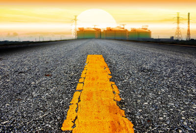 Close-up of yellow railroad track against sky during sunset
