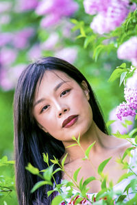 Portrait of beautiful woman against pink flowering plants