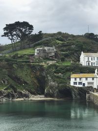 Scenic view of river by buildings against sky