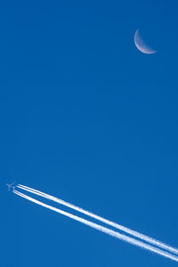 Low angle view of vapor trail against blue sky