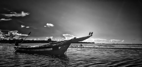 Man fishing in sea against sky