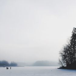 Scenic view of frozen lake against sky during foggy weather