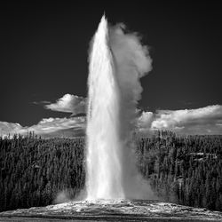 View of waterfall against cloudy sky