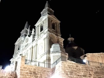 Low angle view of illuminated cathedral against sky at night