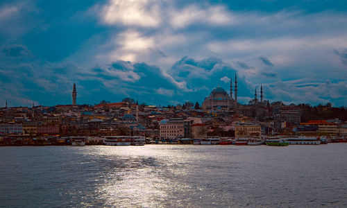 Buildings in city against cloudy sky