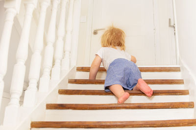 Rear view of woman sitting on staircase