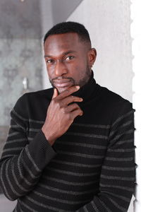 Portrait of man standing against wall