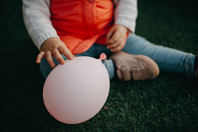 Midsection of man holding ball on grass