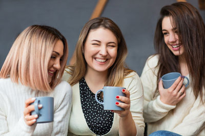 Portrait of smiling young woman with coffee