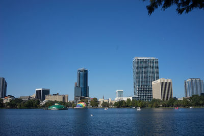 Sea by city against clear blue sky