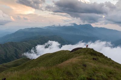 Scenic view of land and mountains against sky