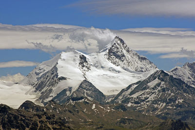 Scenic view of mountains against cloudy sky