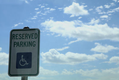 Close-up of information sign against blue sky