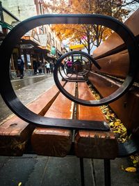 Close-up of bicycle wheel by railing in city