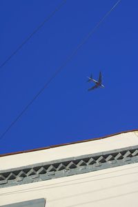 Low angle view of power lines against clear sky