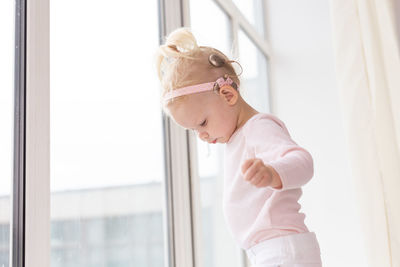 Side view of young woman looking through window