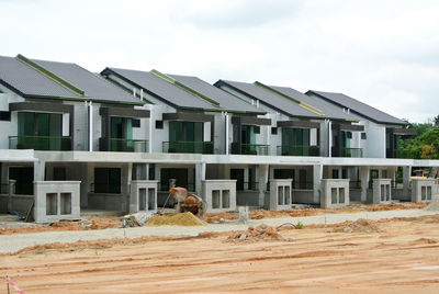 People working on building terrace against sky