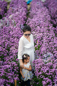 Woman standing on purple flowering plants