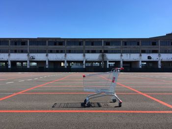 View of shopping cart on road against blue sky