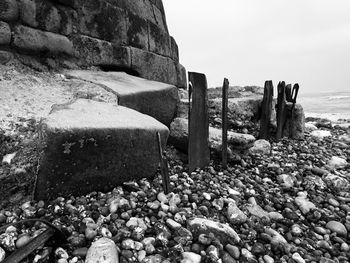 Stones on beach by sea against sky