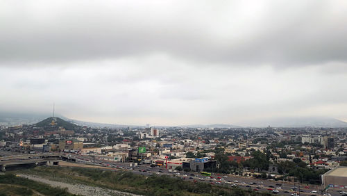 High angle view of city against cloudy sky