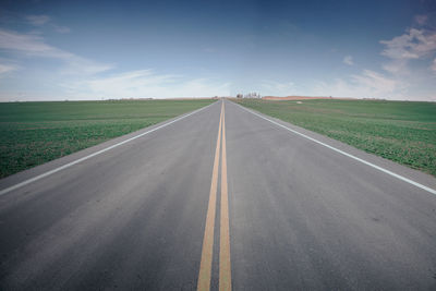 Empty road along countryside landscape