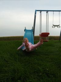 Full length of girl playing on slide at park