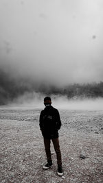 Full length of man wearing mask standing on land against sky