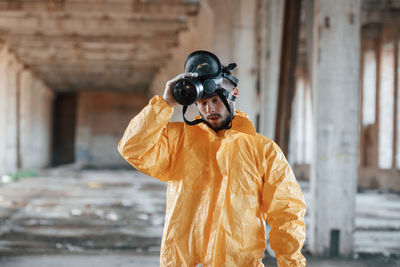 Side view of man photographing while standing outdoors