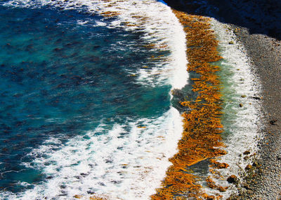 High angle view of waves rushing towards shore