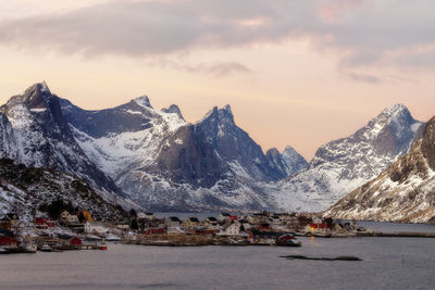 Scenic view of snowcapped mountains against cloudy sky during winter