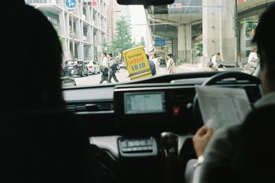 People seen through car windshield