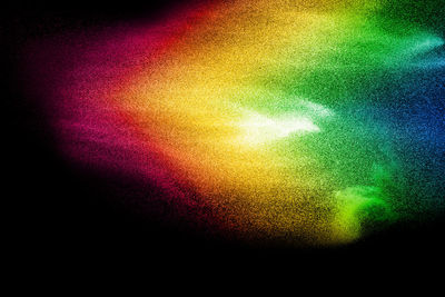 Defocused image of multi colored powder paints against black background