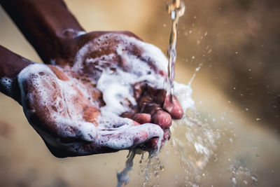 Close-up of hand holding wet leaf